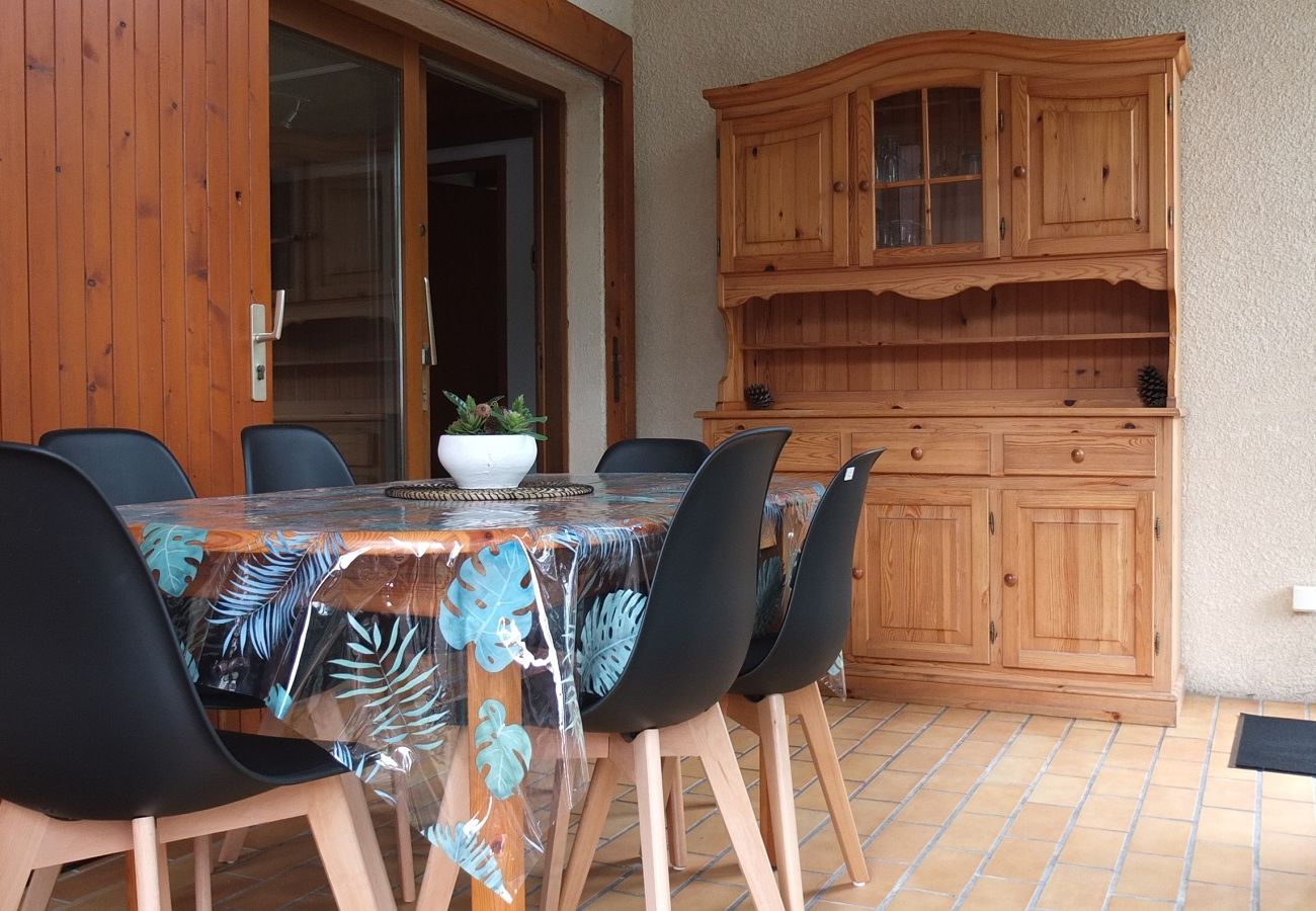 Salle à manger avec une table pour 6 personnes sous une véranda