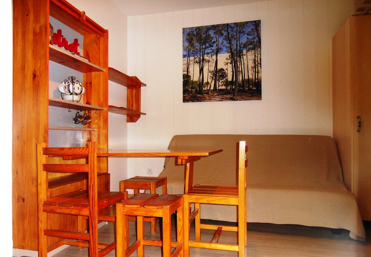 Table à manger en bois repliable sur le mur avec deux tabourets et deux chaises